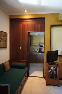 a living room with a couch and a tv in a room at Pondok Agung Bed & Breakfast in Nusa Dua