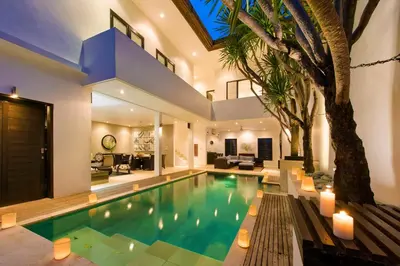 a swimming pool in a house with a tree at The Town House in Seminyak