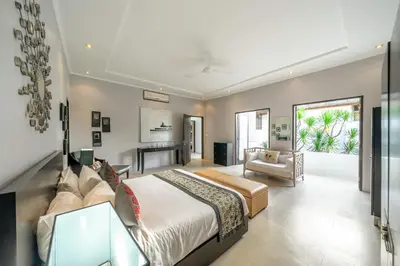 a bedroom with a large bed and a desk at The Town House in Seminyak