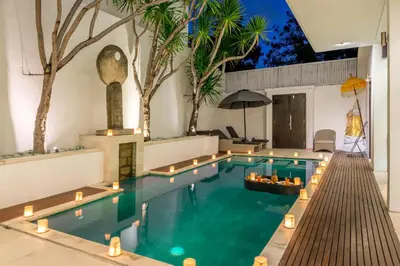 a swimming pool with lights in a house at The Town House in Seminyak