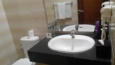 a bathroom with a sink and a toilet at Kuta Central Park Hotel in Kuta