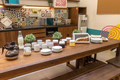 a wooden table with plates and utensils on it at M Boutique Hostel Legian in Legian