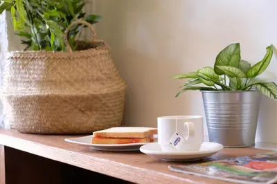 a table with a sandwich and a cup of coffee at M Boutique Hostel Legian in Legian