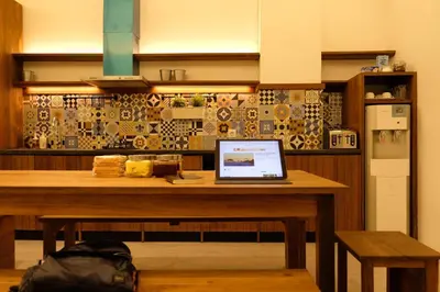 a laptop computer sitting on a wooden table in a kitchen at M Boutique Hostel Legian in Legian