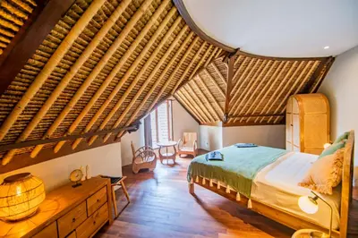 a bedroom with a large bed with a wooden ceiling at SuB Villas Bali in Canggu