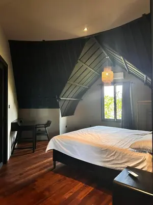 a bedroom with a large bed and a window at SuB Villas Bali in Canggu