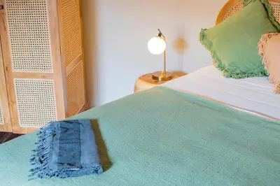 a bedroom with a bed with a blue blanket on it at SuB Villas Bali in Canggu