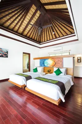 two beds in a bedroom with a roof at Sunset Paradise Jimbaran 3003 in Jimbaran
