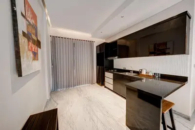 a kitchen with black and white cabinets and a counter at Mokko Suite Villas Umalas Bali in Seminyak