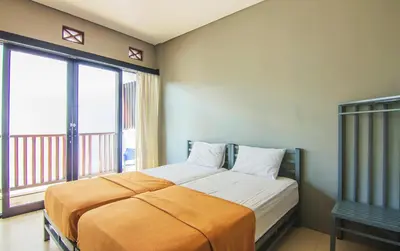 a bedroom with a bed and a large window at The Kubu Hotel in Kuta