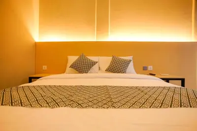 a bedroom with a large bed with two pillows at The Kubu Hotel in Kuta