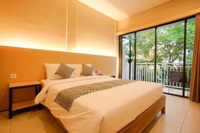 a bedroom with a large bed and a large window at The Kubu Hotel in Kuta