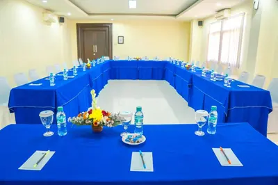 a blue conference room with a table with a blue table cloth at Hotel Puri Ayu in Denpasar