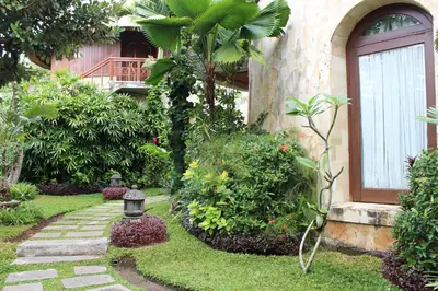 a garden with a lantern in the grass next to a building at Dewani Villa Resort in Canggu