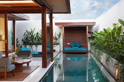 an infinity pool in the middle of a house at Maca Villas & Spa Bali in Seminyak