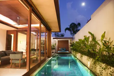 an infinity pool in a house with a living room at Maca Villas & Spa Bali in Seminyak