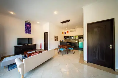 a living room with a couch and a television at The Tukad Villa in Seminyak