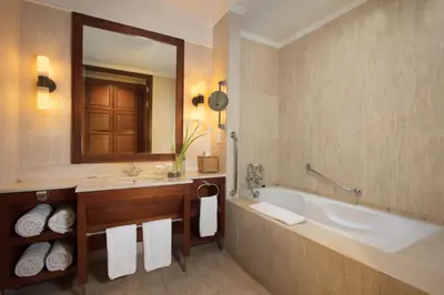 a bathroom with a tub and a sink and a mirror at The Patra Bali Resort & Villas - CHSE Certified in Kuta