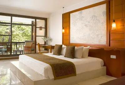 a bedroom with a bed with a large painting on the wall at The Patra Bali Resort & Villas - CHSE Certified in Kuta