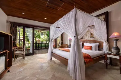 a bedroom with a bed with a canopy at Bali Tropic Resort & Spa - CHSE Certified in Nusa Dua