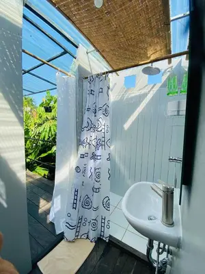 a bathroom with a sink and a shower curtain at Kampoeng Saya in Seminyak