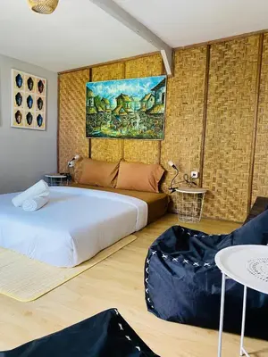 a bedroom with a large bed and a table at Kampoeng Saya in Seminyak