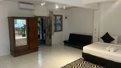 a bedroom with a bed and a couch in it at Kampoeng Saya in Seminyak