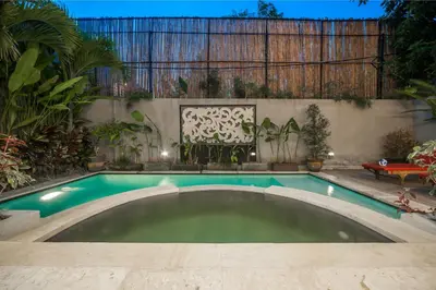 a swimming pool in a backyard with a fence at Villa Suzuki 1 Seminyak in Seminyak