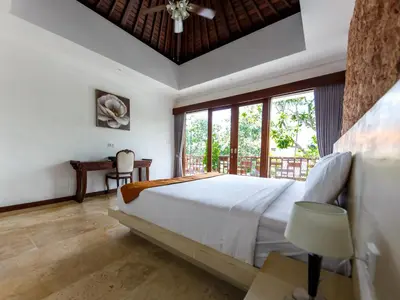 a bedroom with a large bed and a large window at Villa Suzuki 1 Seminyak in Seminyak