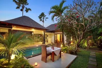 a house with a table in front of a pool at The Buah Bali Villas in Seminyak