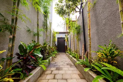 a walkway in a building with plants and a door at Villa Suzuki 3 Seminyak in Seminyak