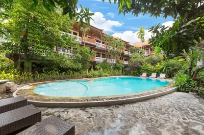 a swimming pool in front of a building at Simpang Inn Hotel in Legian