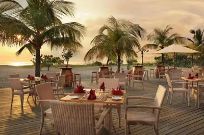 a restaurant on the beach with tables and chairs at Bintang Bali Resort in Kuta