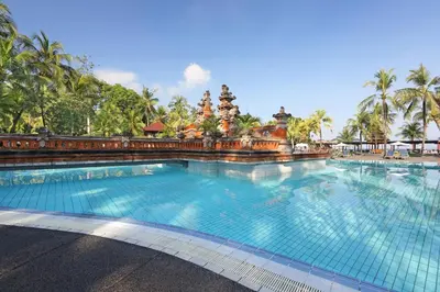 a large swimming pool at a resort with palm trees at Bintang Bali Resort in Kuta