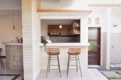 a kitchen with two bar stools and a counter at Villa Lapiz Lazuli Seminyak Kuta in Seminyak