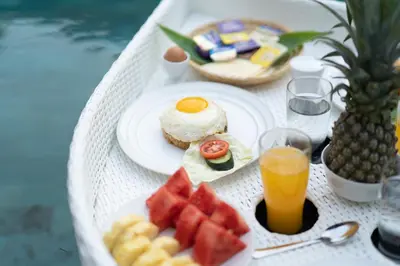 a white table with breakfast foods and drinks on it at Villa Lapiz Lazuli Seminyak Kuta in Seminyak