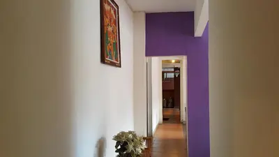 a hallway with purple walls and a painting on the wall at Guest House Matahari in Kuta
