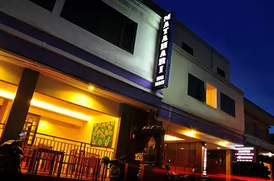 a building with a sign on the side of it at night at Guest House Matahari in Kuta