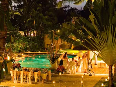 a group of people standing by a swimming pool at night at Sienna Villas Seminyak in Seminyak