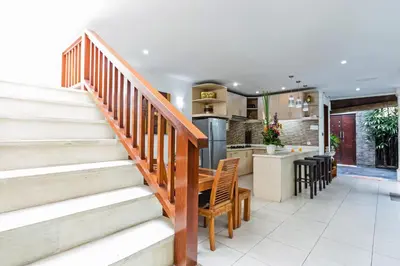 a kitchen and living room with stairs and a counter at Villa Mienna in Seminyak