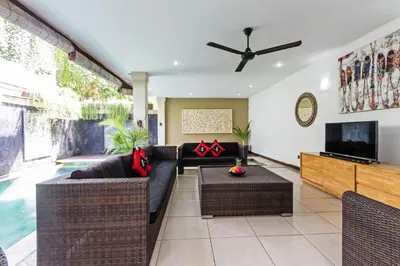 a living room with a couch and a tv at Villa Mienna in Seminyak