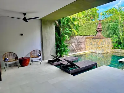 a patio with two chairs and a swimming pool at Villa 80361 in Seminyak