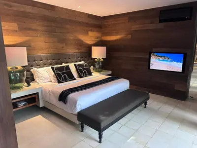 a bedroom with a bed and a tv on a wall at Villa 80361 in Seminyak