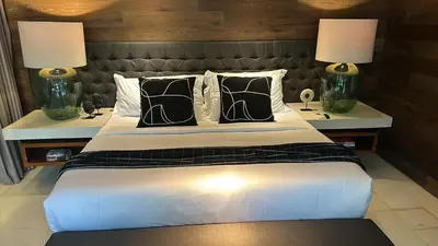 a bedroom with a large bed with two lamps at Villa 80361 in Seminyak