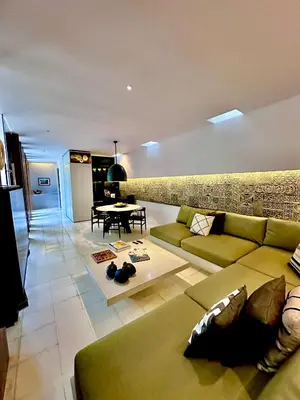 a living room with a green couch and a table at Villa 80361 in Seminyak