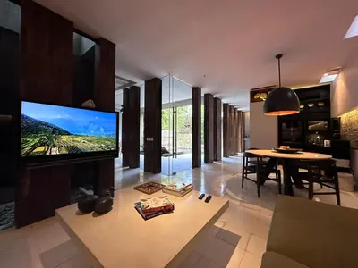 a living room with a tv and a dining room at Villa 80361 in Seminyak
