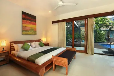 a bedroom with a large bed and a large window at Villa Blue in Seminyak