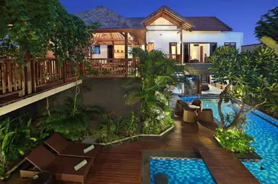 a villa with a swimming pool in front of a house at Villa Blue in Seminyak
