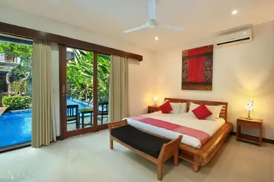 a bedroom with a bed and a large window at Villa Blue in Seminyak
