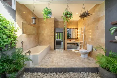 a bathroom with a tub and a toilet and plants at Villa Sarong 1 in Seminyak